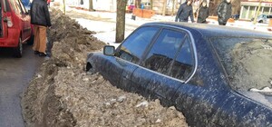 В Запорожье коммунальщики закопали машину в грязный снег