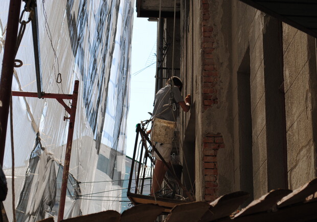 Строители восстанавливают балконы жилых домов, требующих реконструкции. Фото: Алексей Битнер.
