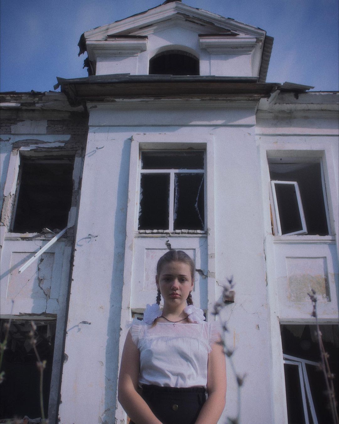 Діти на тлі зруйнованої школи у Харкові -