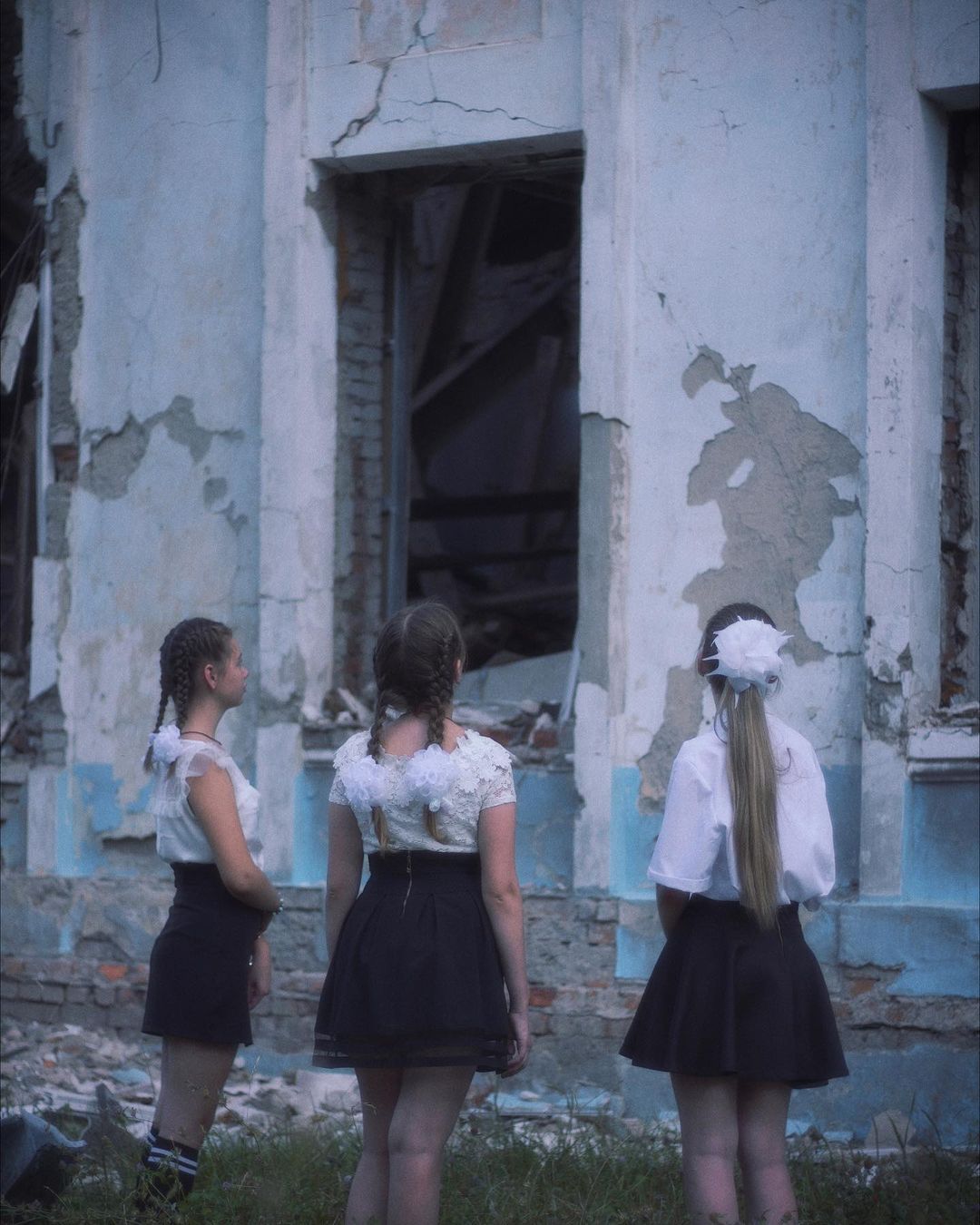 Діти на тлі зруйнованої школи у Харкові -