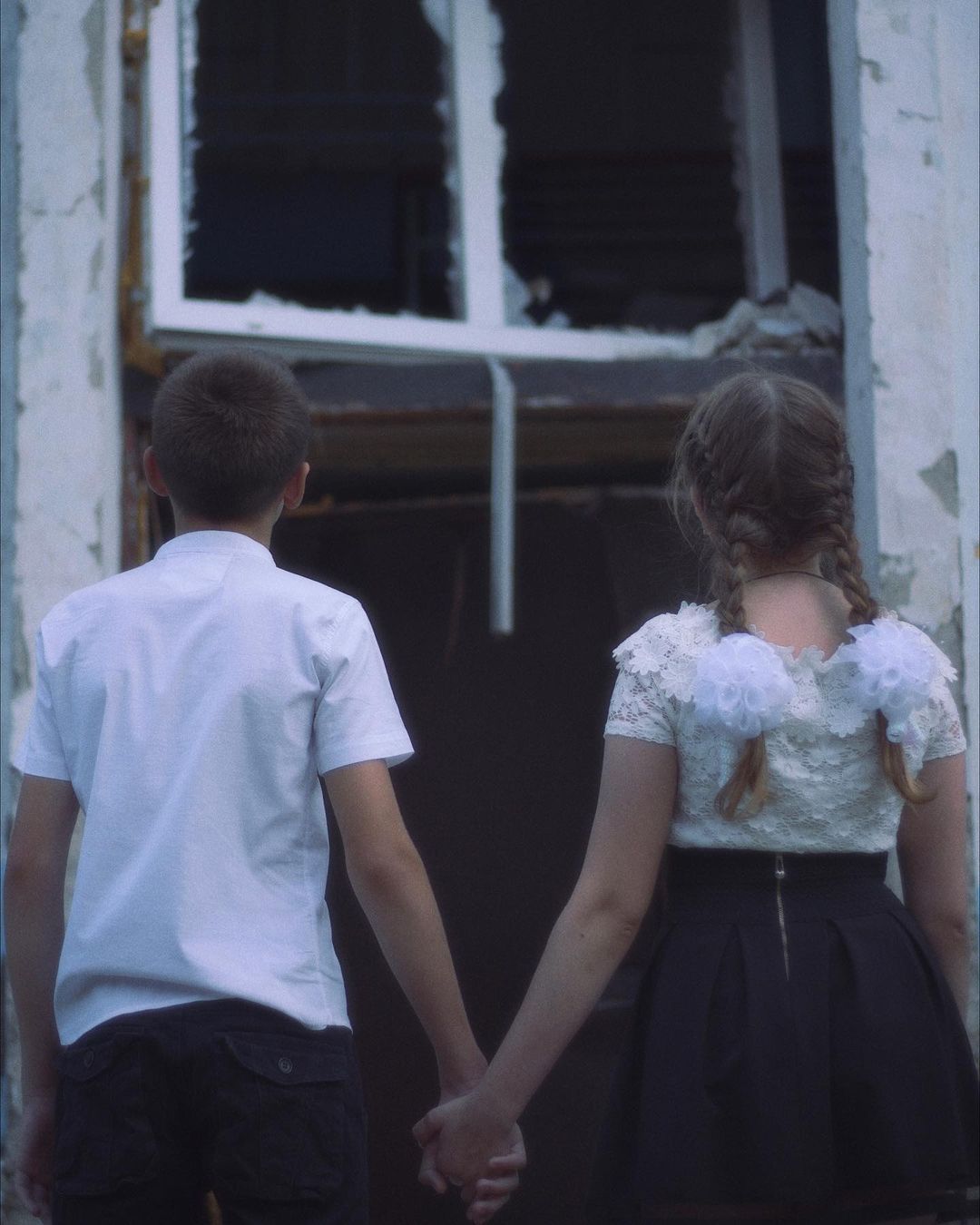 Діти на тлі зруйнованої школи у Харкові -