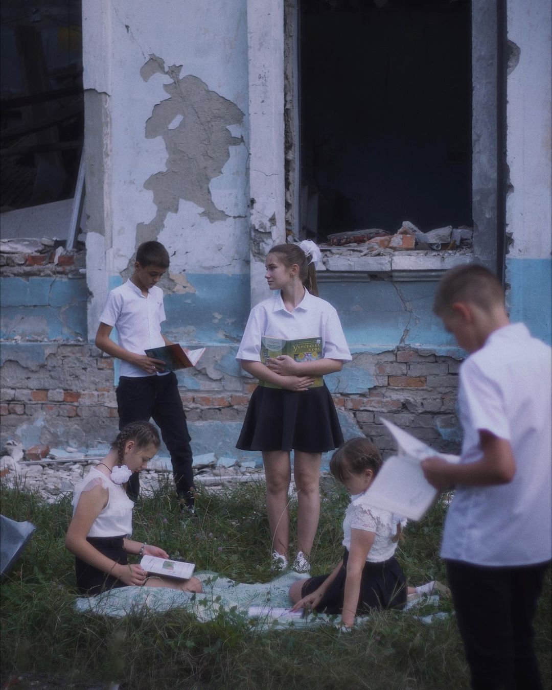 Діти на тлі зруйнованої школи у Харкові -