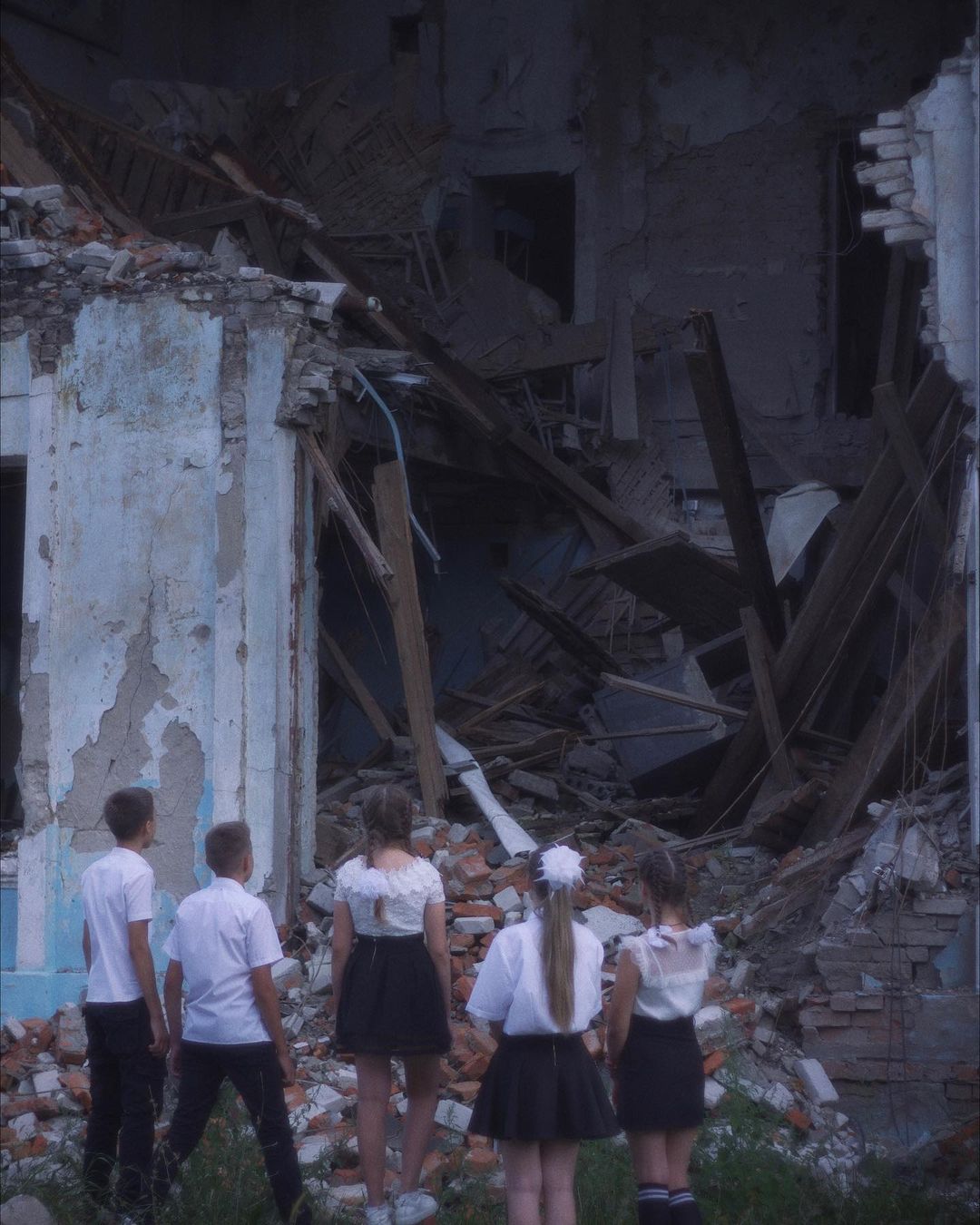Діти на тлі зруйнованої школи у Харкові -