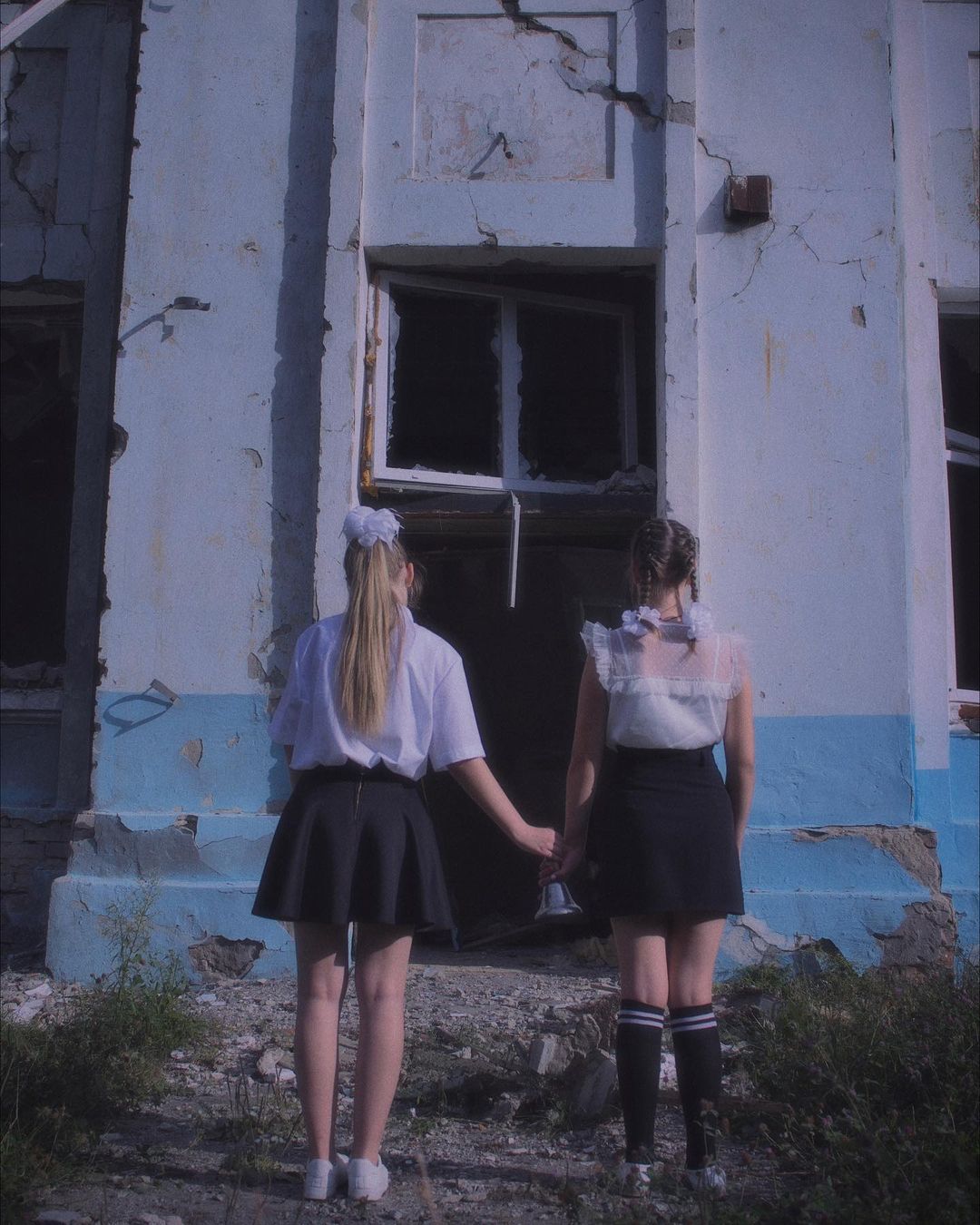 Діти на тлі зруйнованої школи у Харкові -