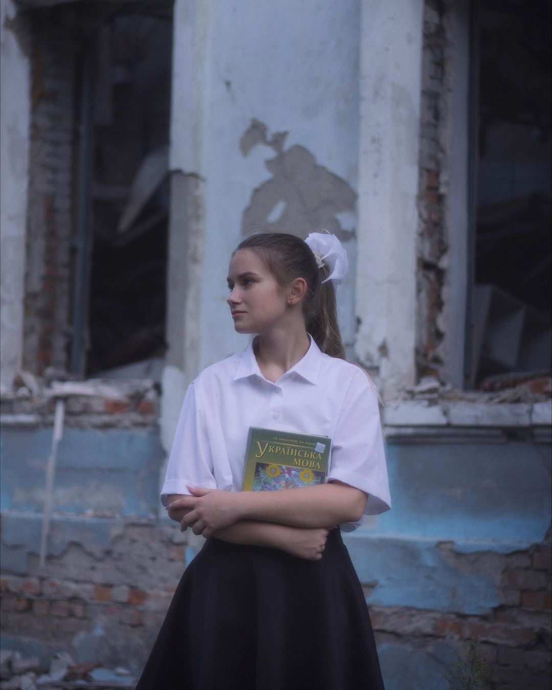 Діти на тлі зруйнованої школи у Харкові -