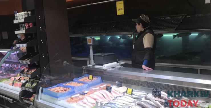 Сотрудница рыбного отдела "Роста" за открытой витриной не носит маску. Фото: KHARKIV Today