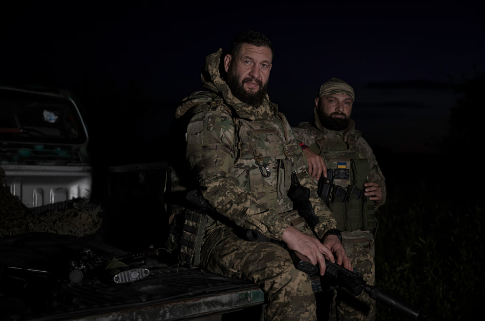 Андрей Щербина, 42 года, и Олег Кушнеров, 36 лет, сидят в кузове своего грузовика после возвращения с задания под Волчанском 27 июня.